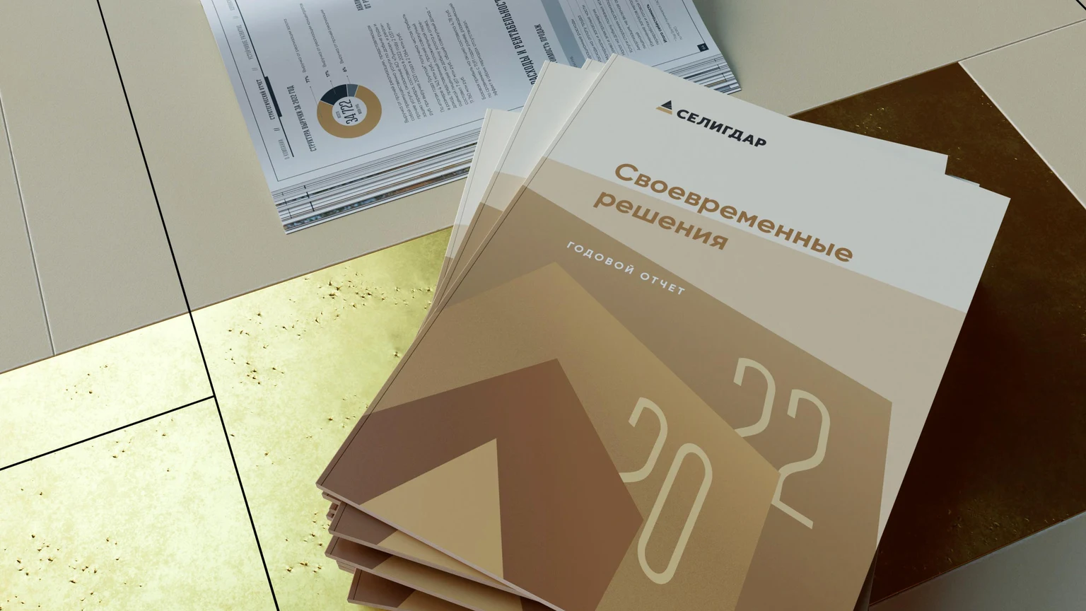 Стопка годовых отчётов Селигдара с золотистой обложкой «Совершенные решения»